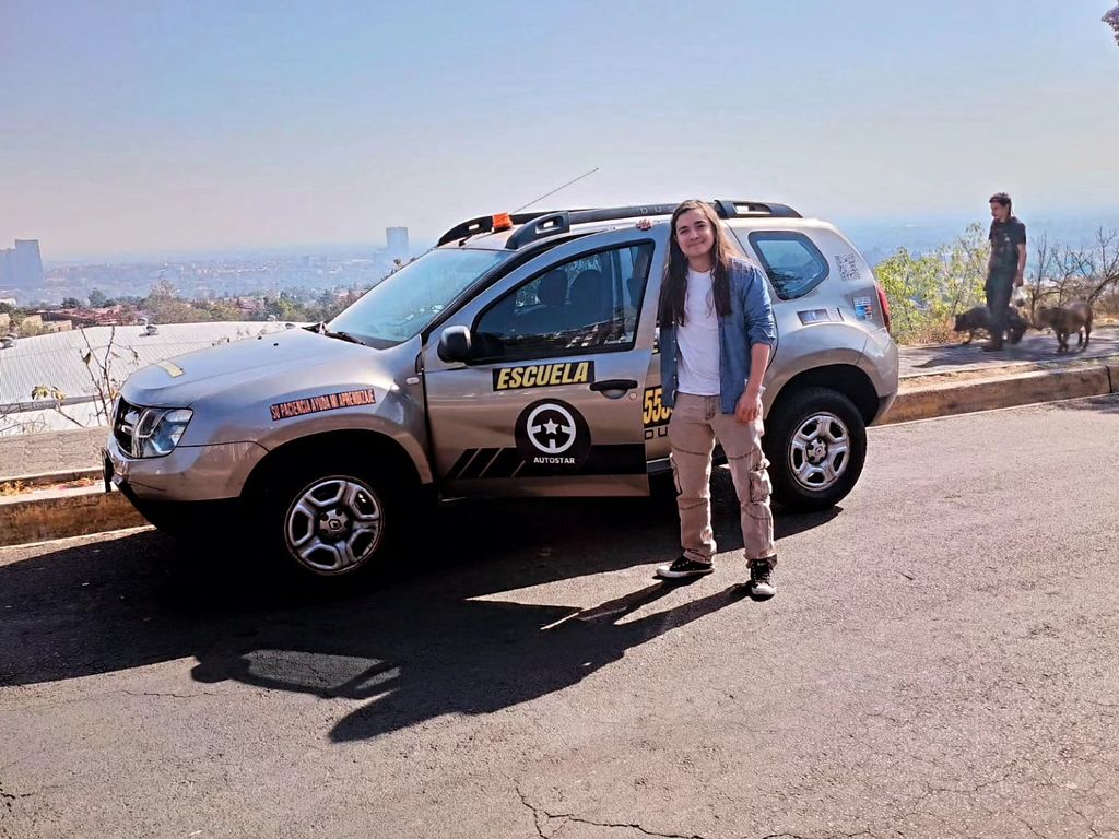 Persona junto a una camioneta de AUTOSTAR en un mirador con vista a la ciudad