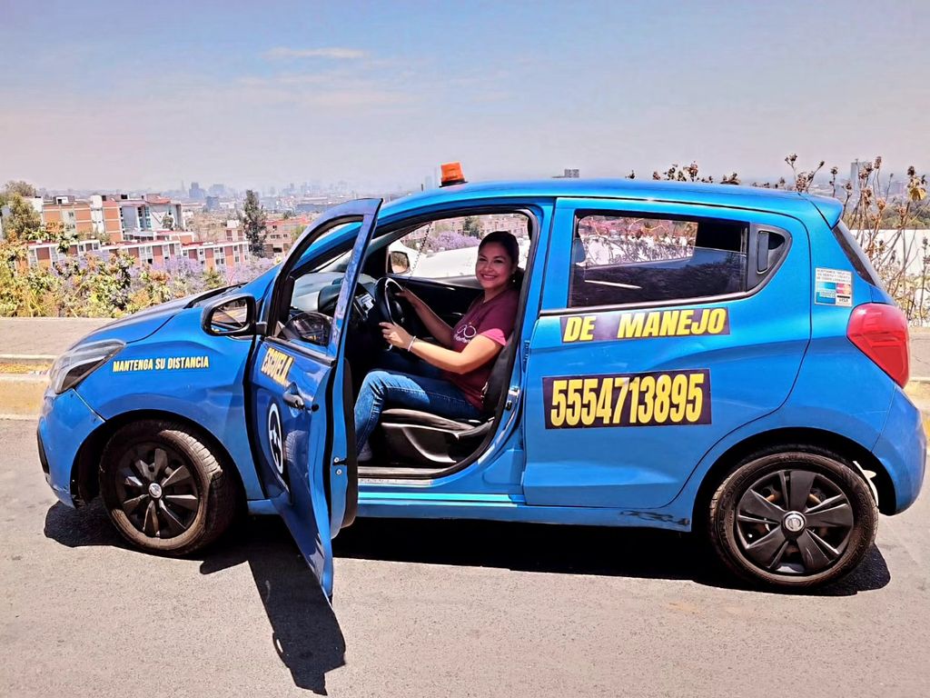 Persona al volante de un auto compacto de AUTOSTAR con la puerta abierta, lista para su clase